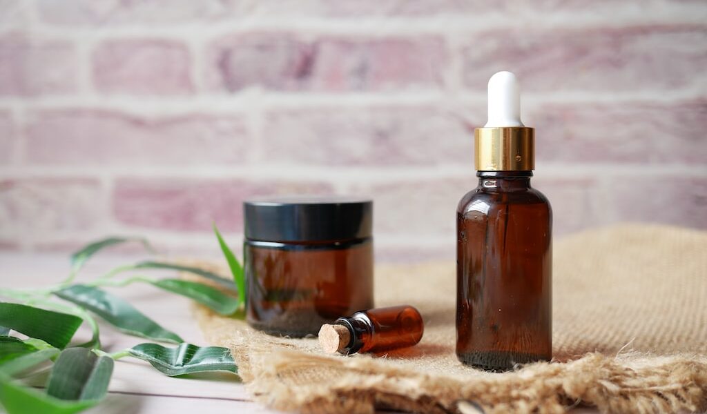 Kosmetyki z ekstraktami roślinnymi stoją na drewnianej desce